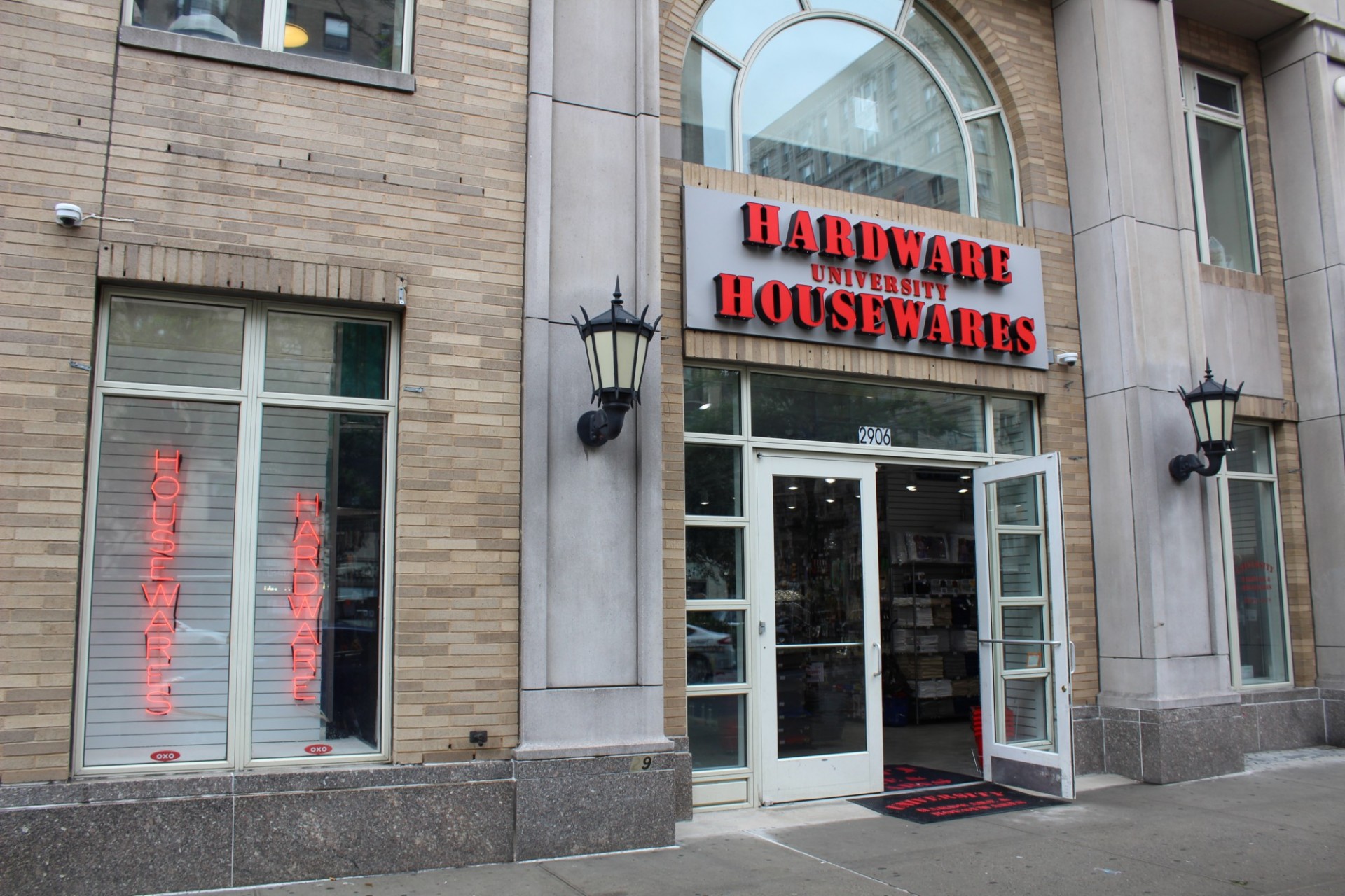The storefront of University Hardware and Housewares with a large red sign and open glass doors.