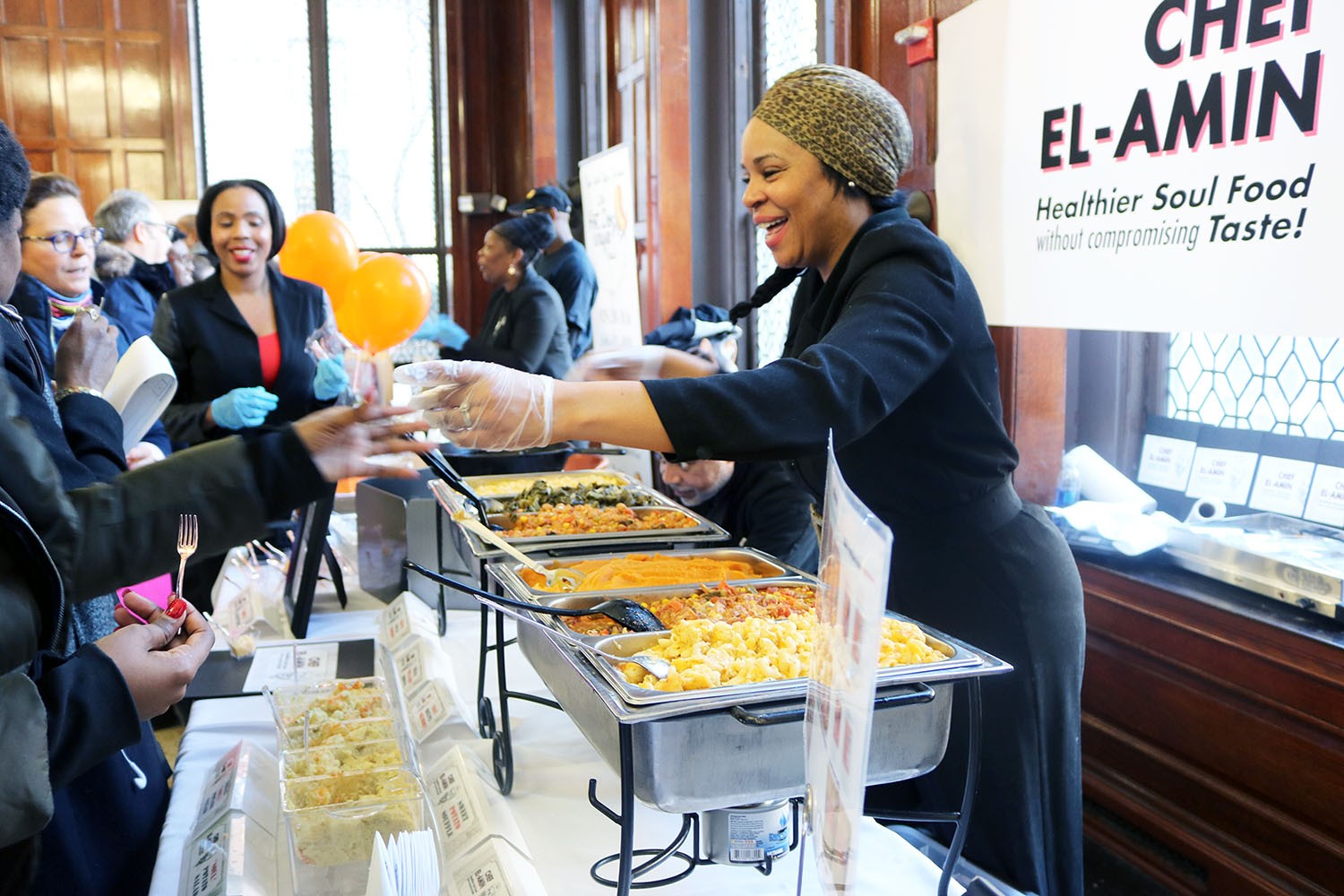 A person hands out samples of their soul food to potential customers at the Harlem Buyer Fair.