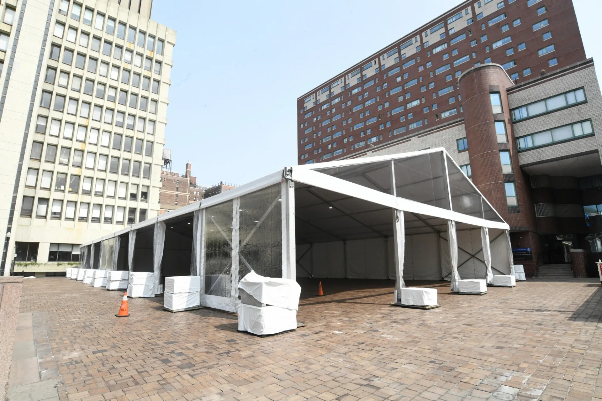 A large white tent is erected on Ancell Plaza between the International Affairs Building and East Campus.