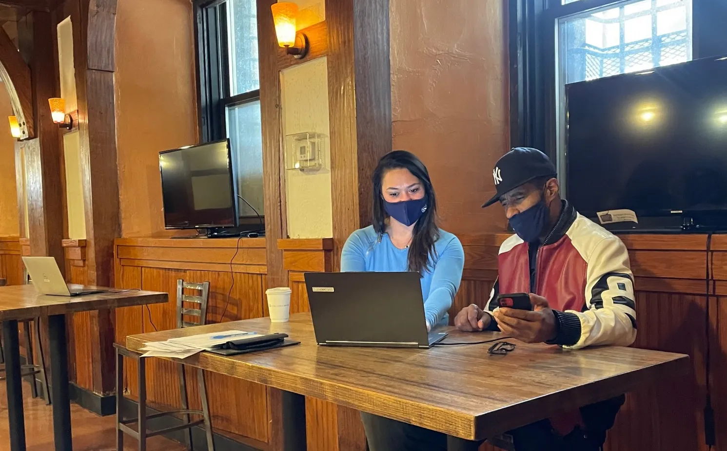 a female and male sitting at a table looking at a laptop
