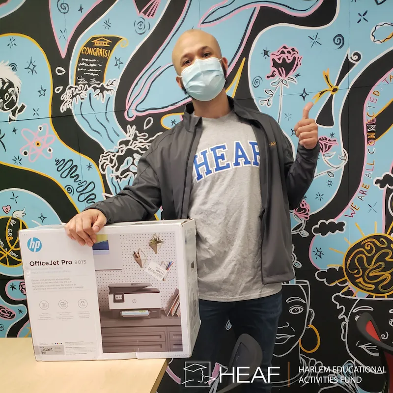 man with face mask with and holding HP printer