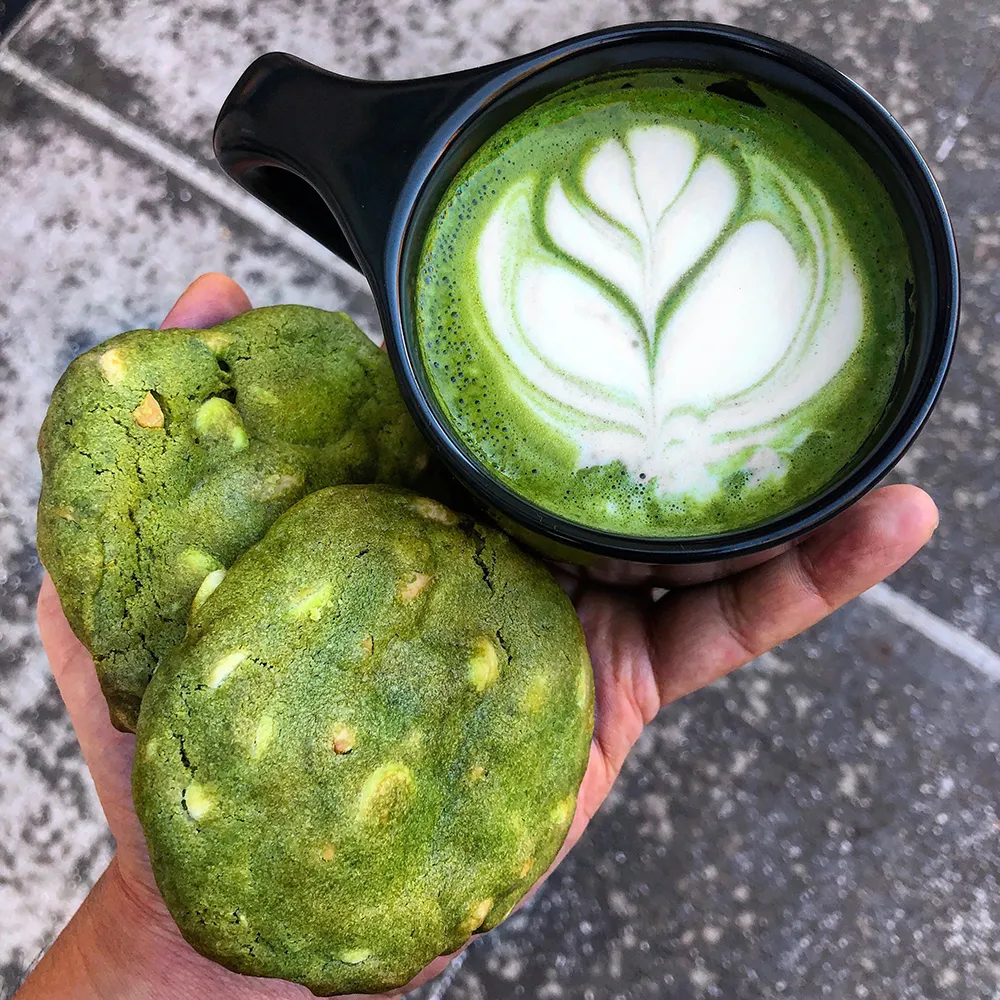 An almond milk matcha latte and two white chocolate almond matcha cookies