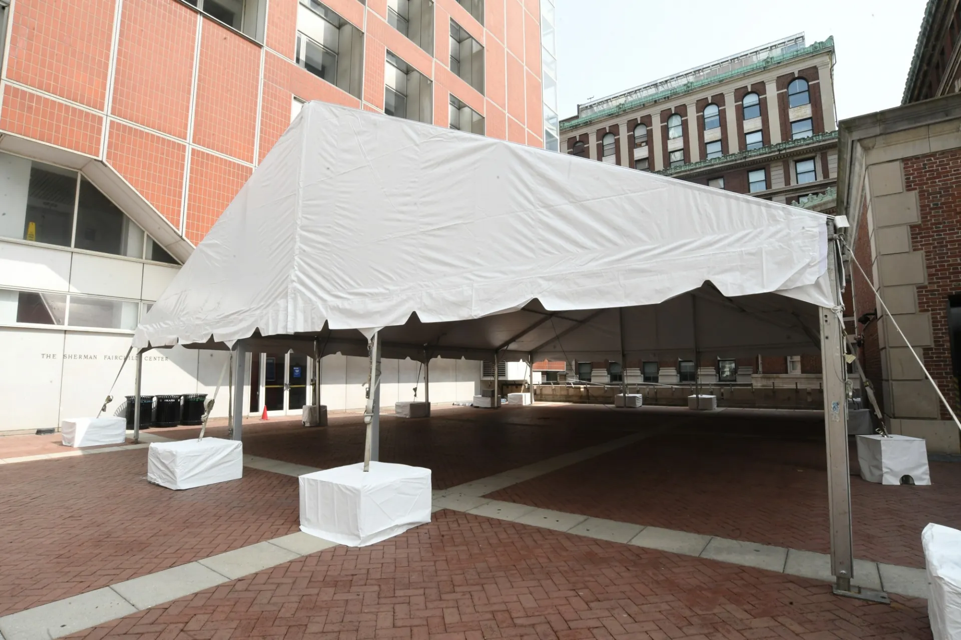 A large white tent is erected next to the Fairchild building.