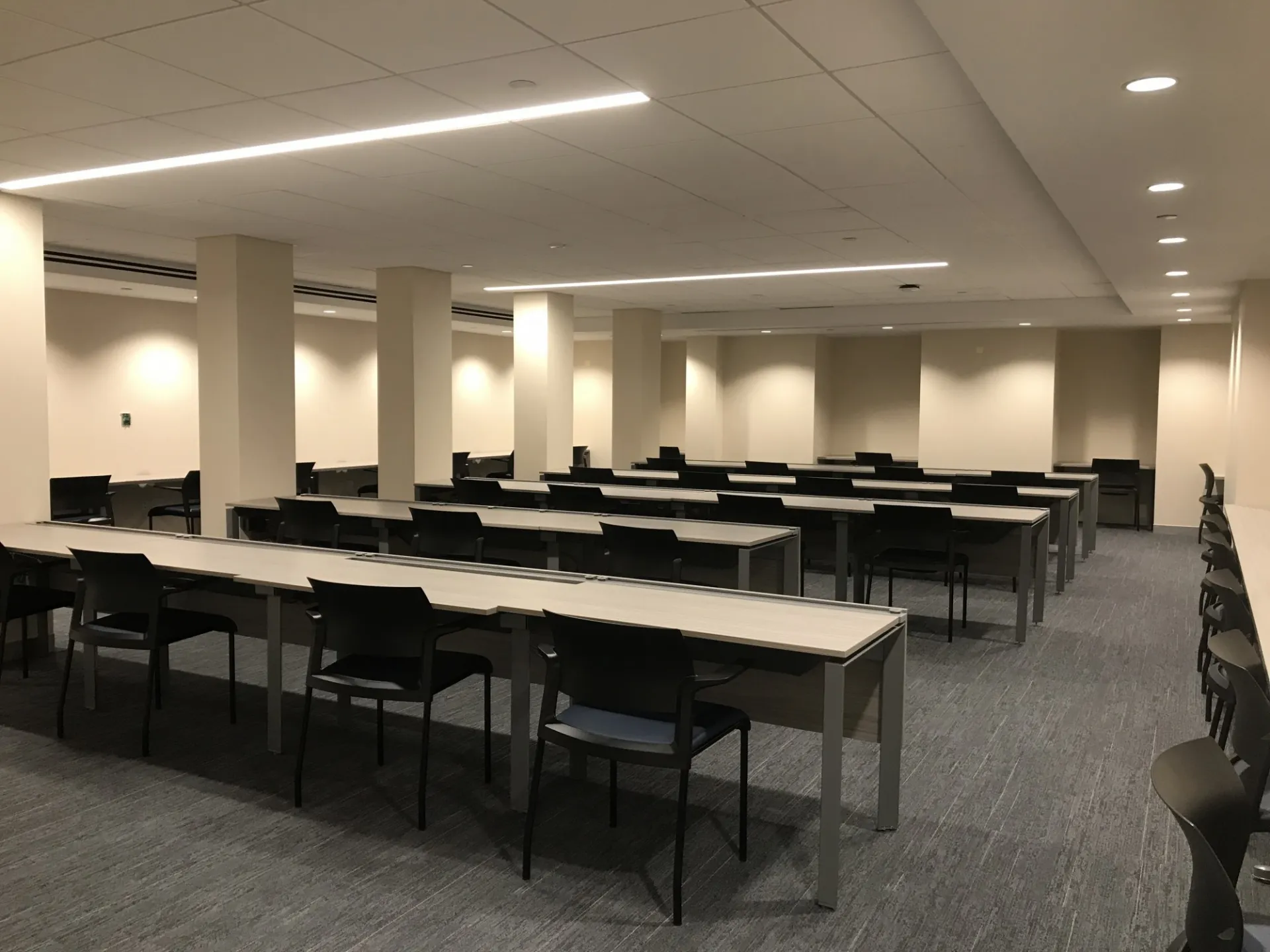A large testing room in Havemeyer Hall with tables and chairs.
