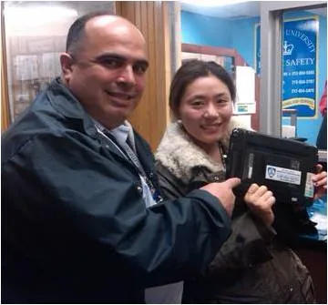 Ricardo Morales, Public Safety's manager of crime prevention programs and Hsiu Lu celebrate the recovery of her laptop. 