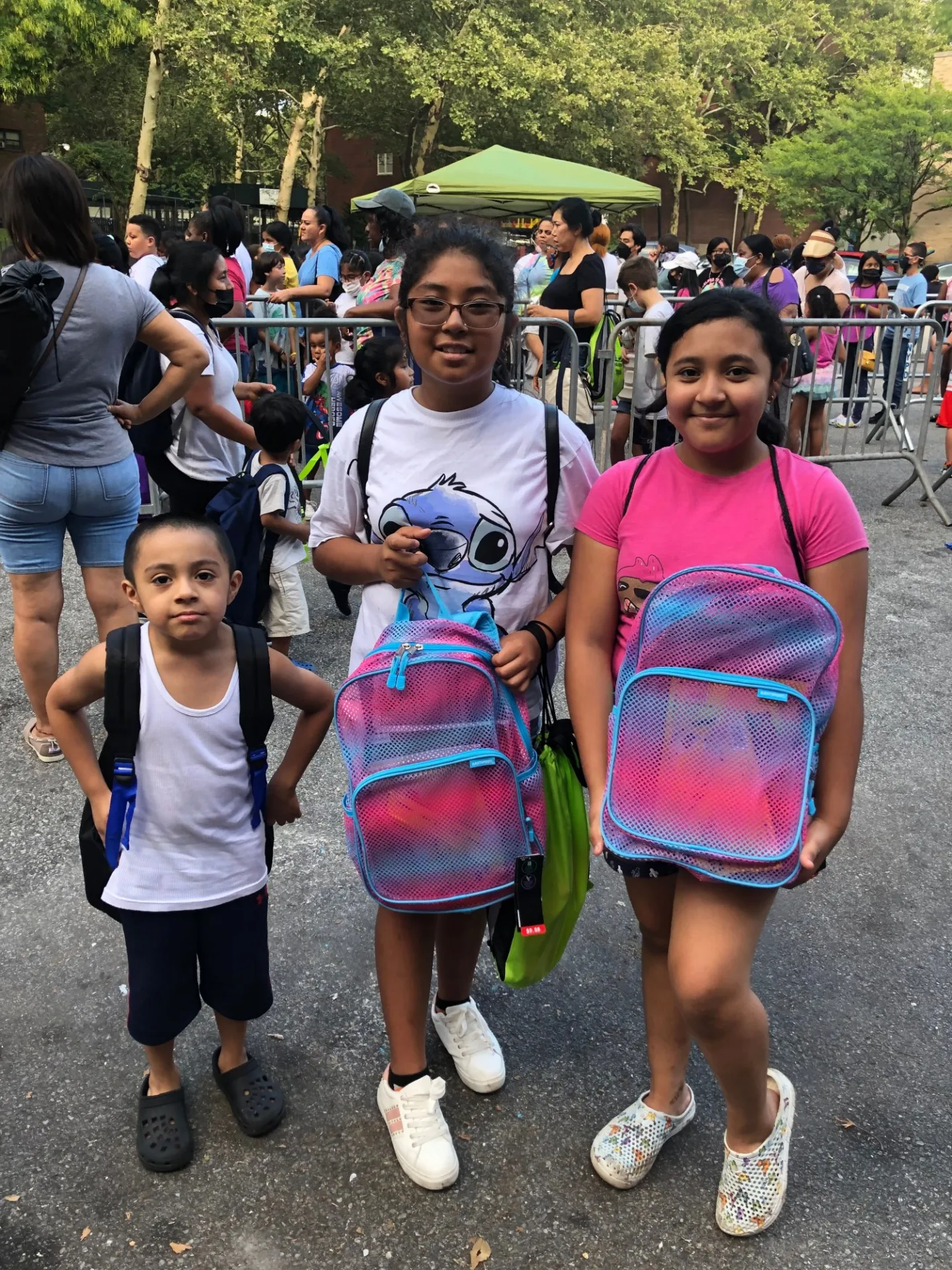 one boy and two girls posing with their new bookbags