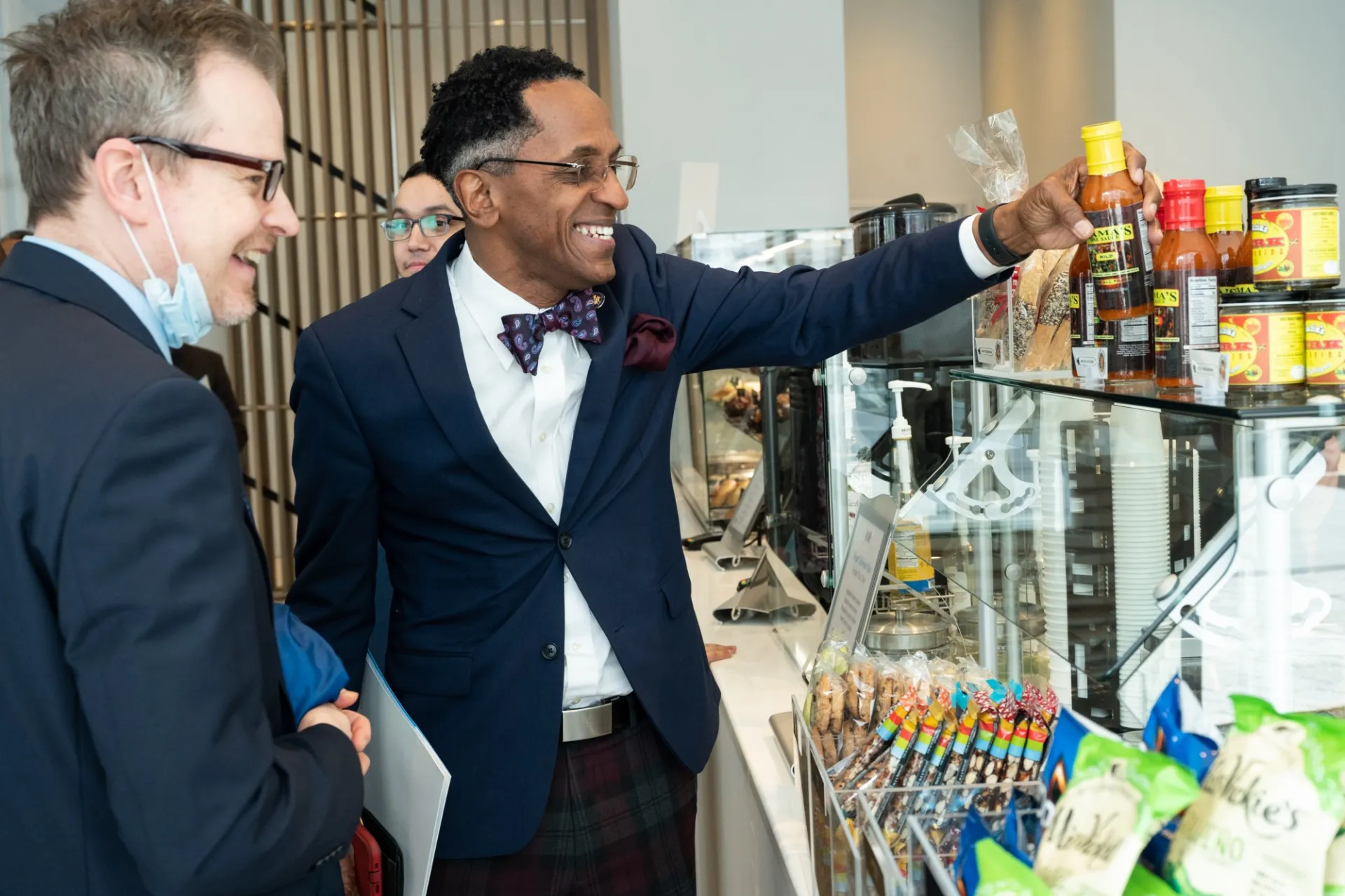 Assembly Member Al Taylor and Nathan Robb, Assistant Vice President for Government Relations in Columbia's Office of Government and Community Affairs, inspect Vy Higgensen's Mama's One Sauce, one of the local items on sale in Geffen Hall's ground floor cafe, which is open to the public. Photo by Diane Bondareff.