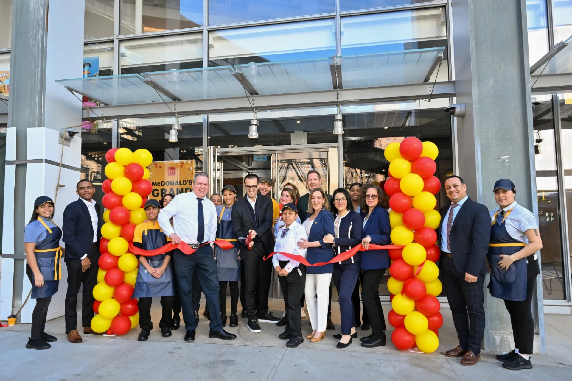 McDonald's employees gather in front of the new McDonald's that opened at 600 W. 125th Street and do a ribbon cutting.
