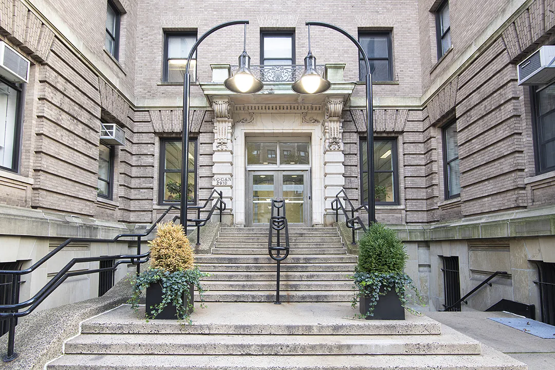 A flight of concrete stairs leads the door or a brick and concrete building