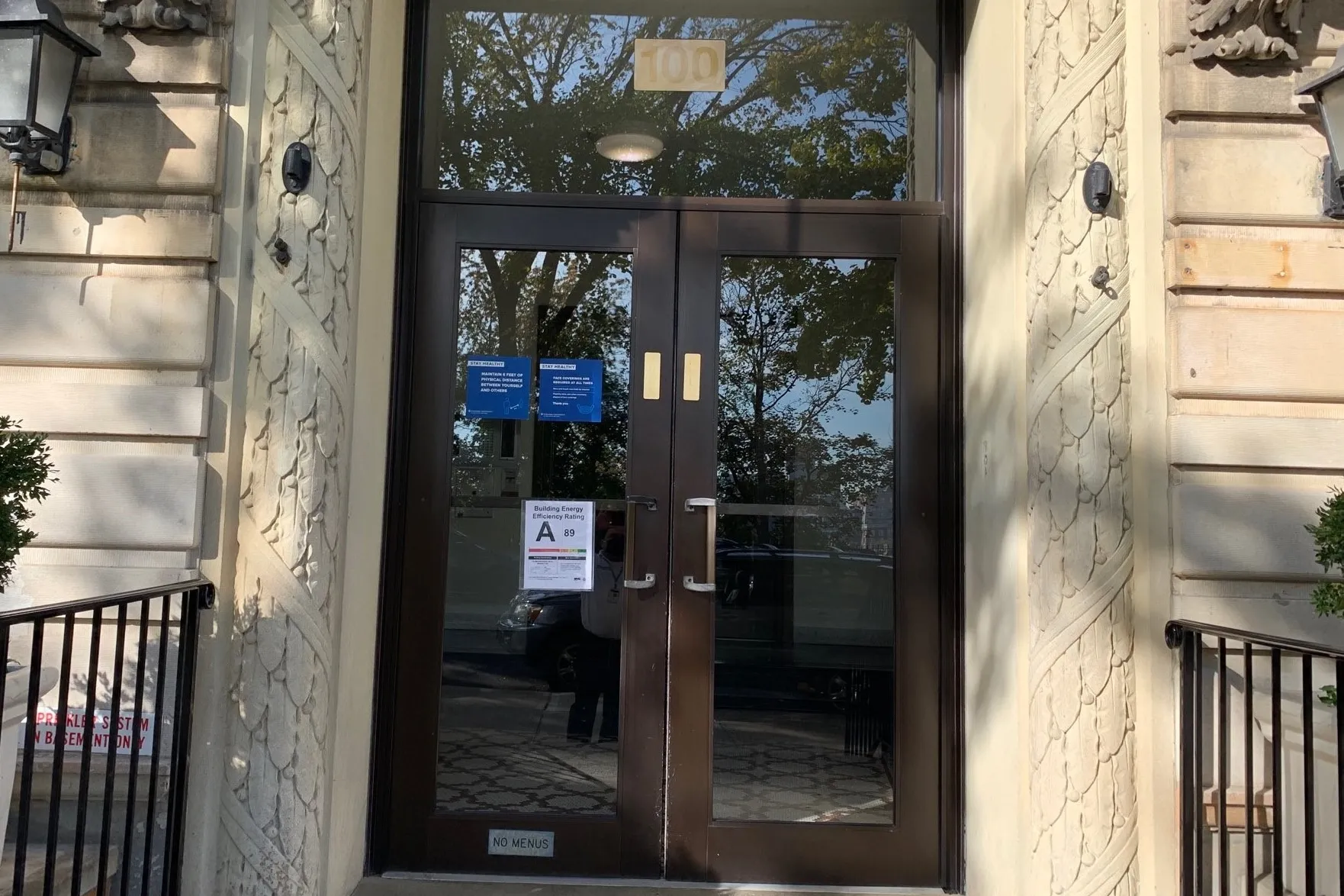 The entrance to a Columbia Residential building that has a building energy efficiency grade sign with an A rating.