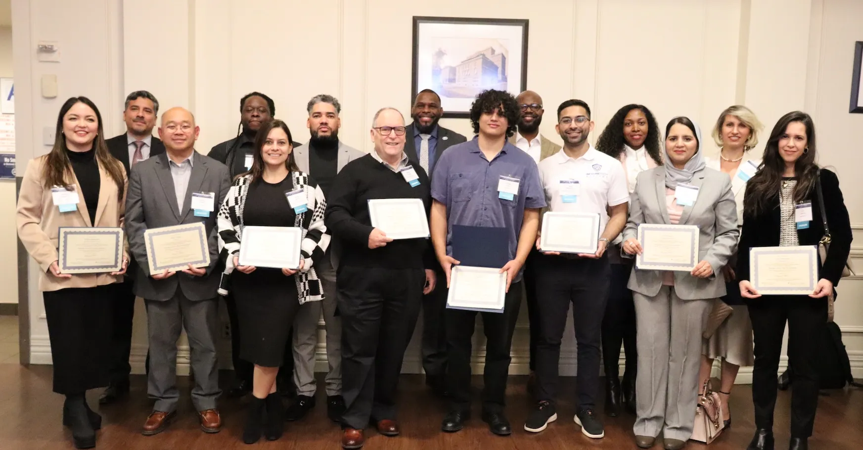 People stand with graduation certificates