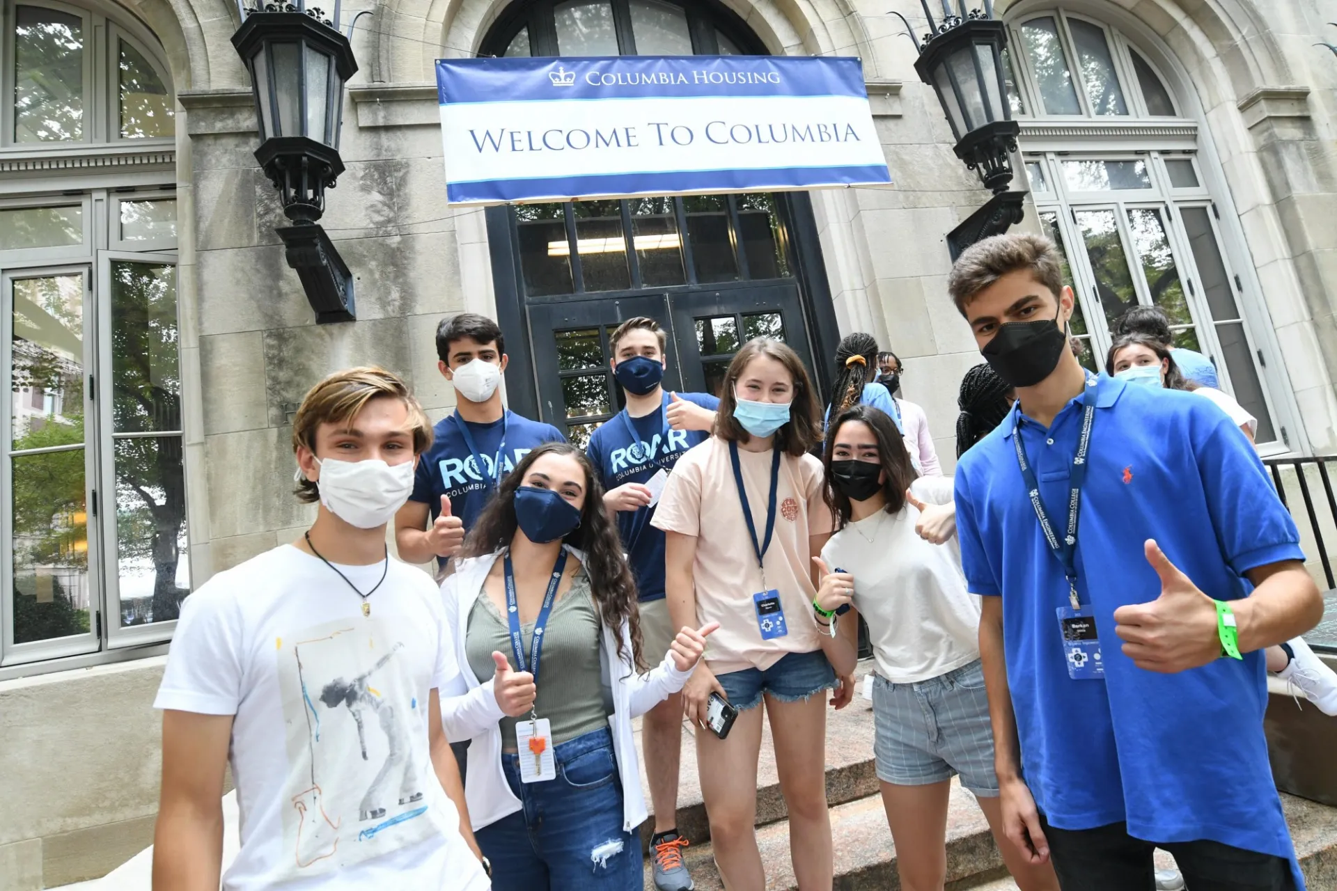 Students standing in front of Hartley Hall and Welcome banner