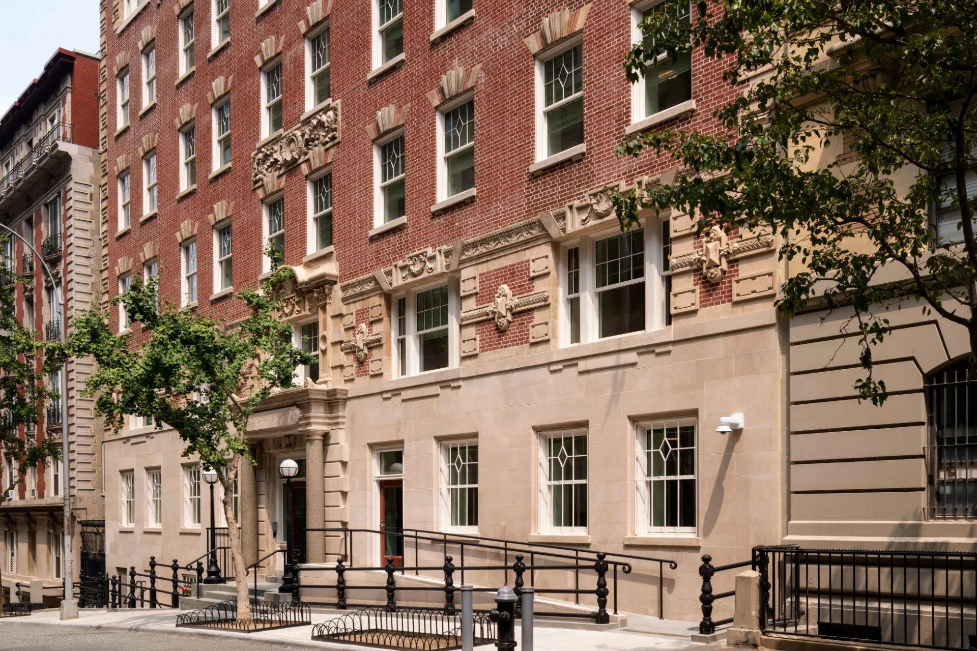 The exterior of 611 W. 112th Street, a historic building with limestone on the ground floor, and brick on the upper levels.