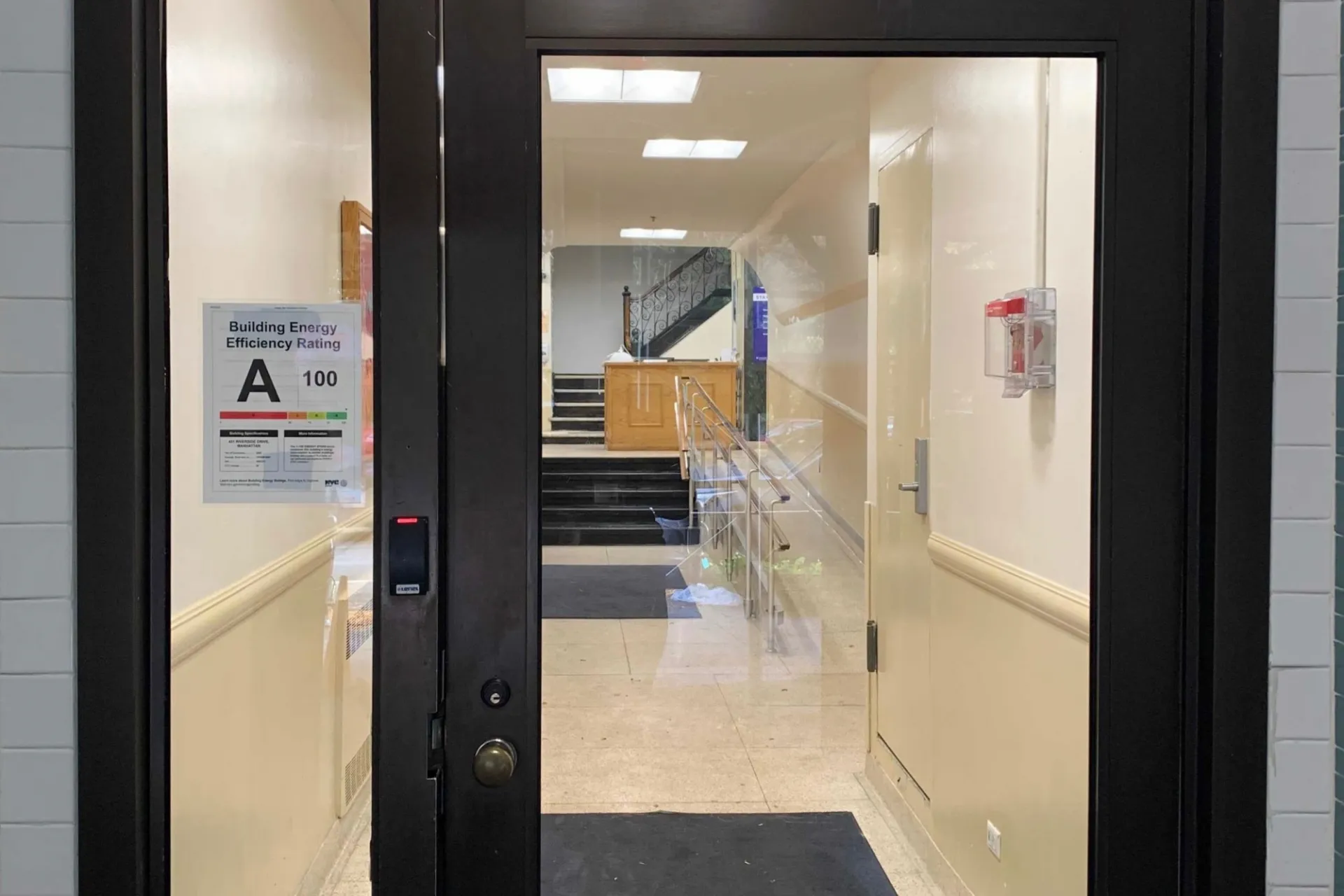 A glass building entrance that has a sign that lists an A grade for the building's energy efficiency rating.