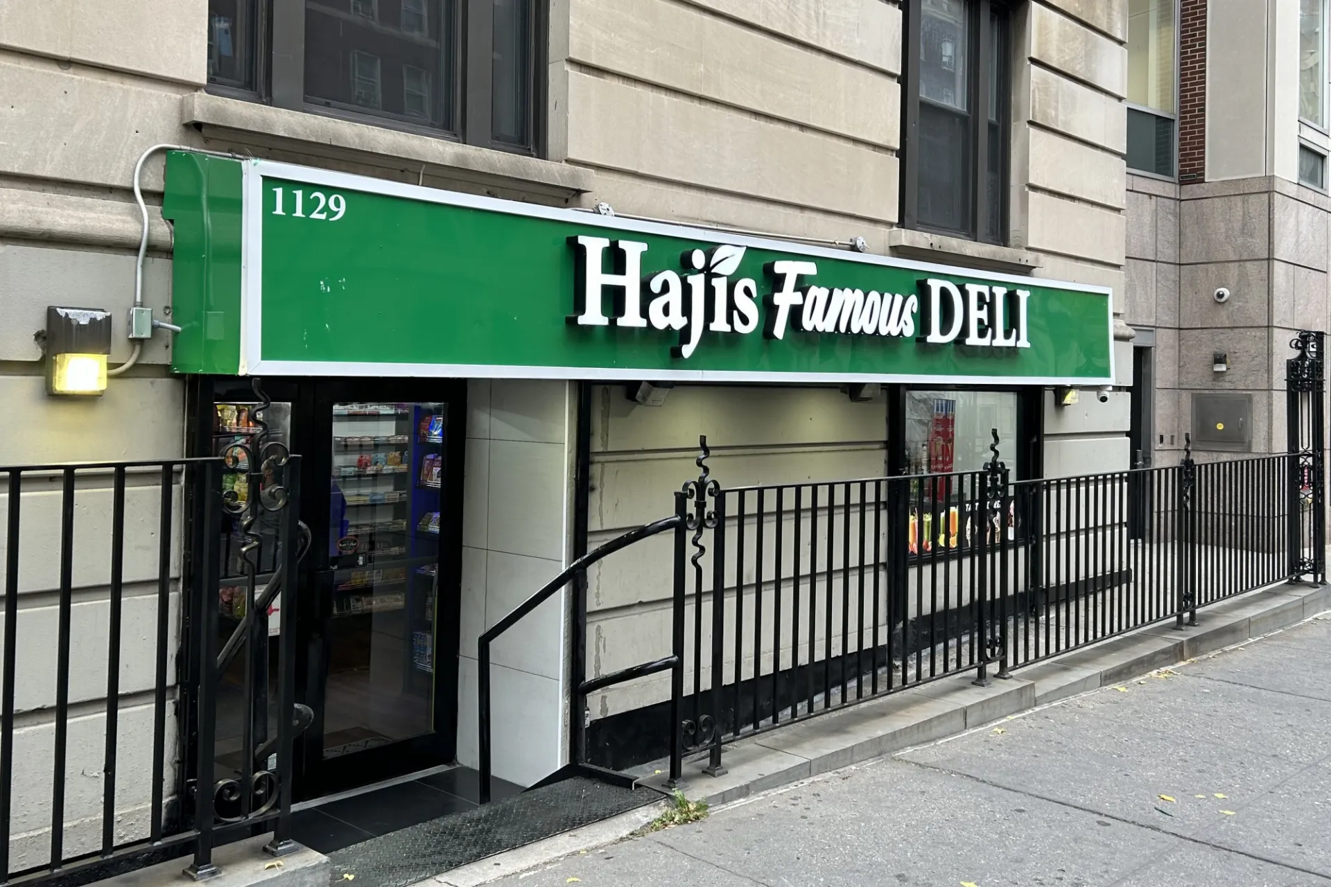 The storefront of Haji's Deli, which has a green sign that says Haji's Famous Deli in white font.