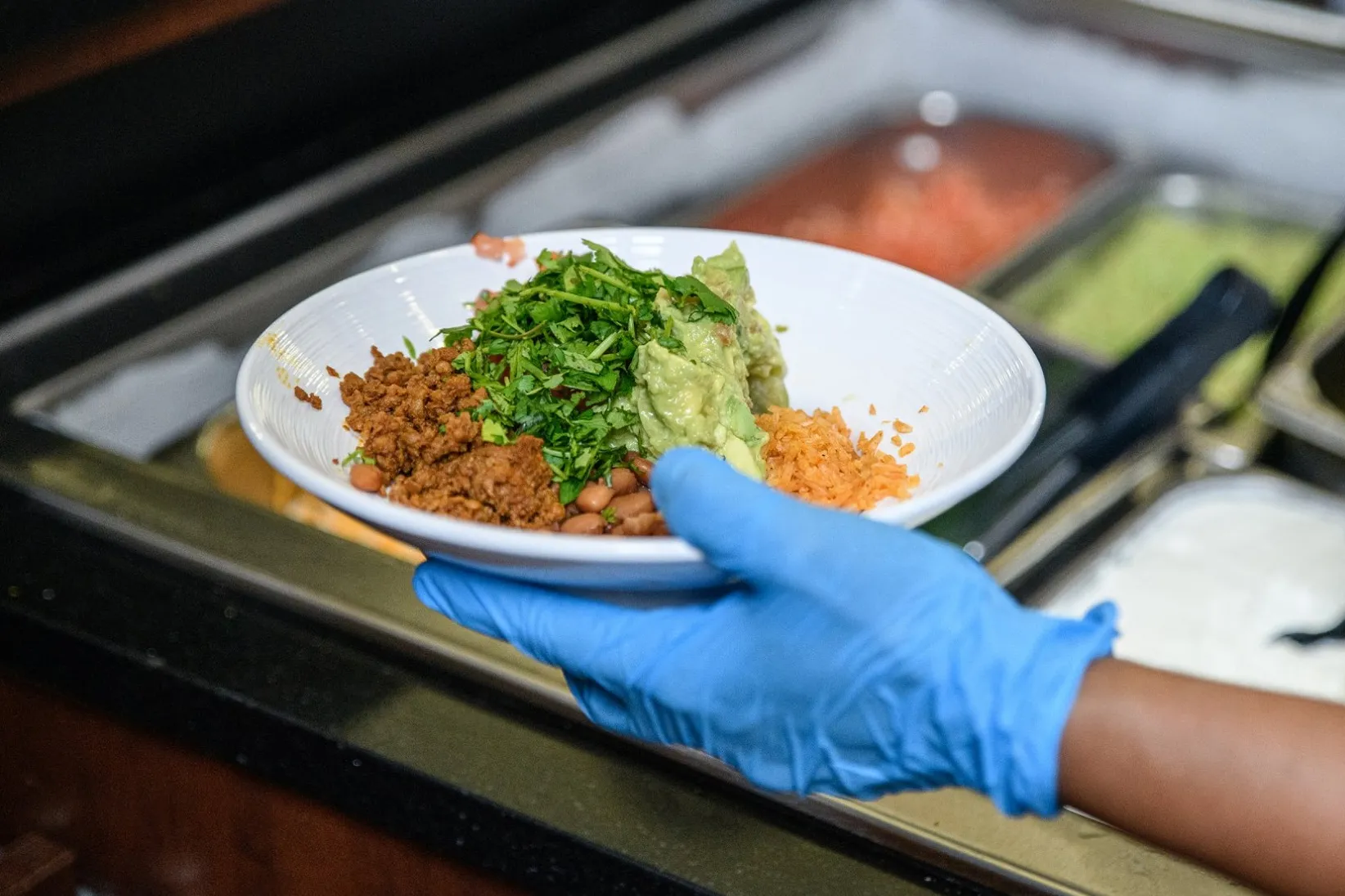 A Columbia Dining employee hands out a plate of food.