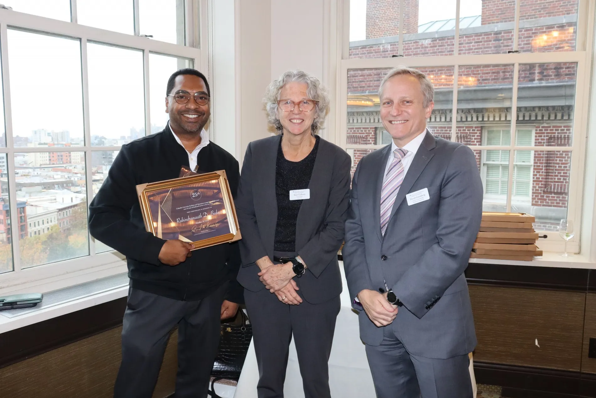 Real Estate employee poses with their supervisor and Executive Vice President David M. Greenberg