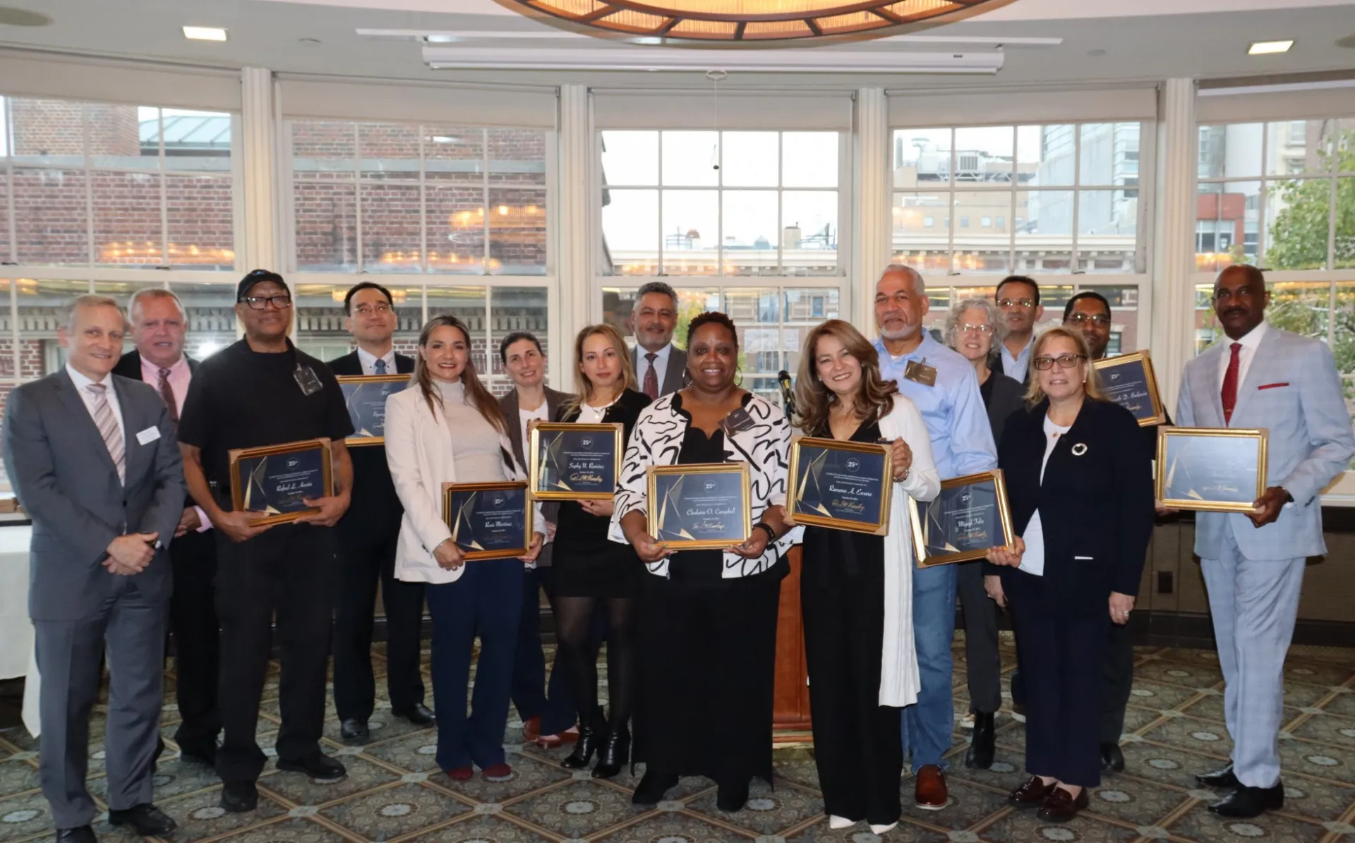 Employees celebrating 25 years of service pose for a group photo with their supervisors