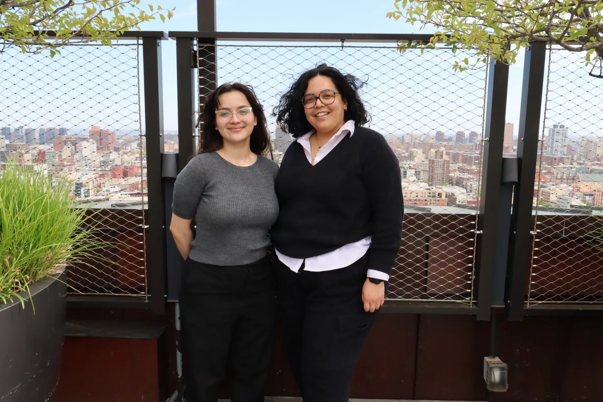 Ashly and Daphne on Butler Hall rooftop with New York City skyline in the background.