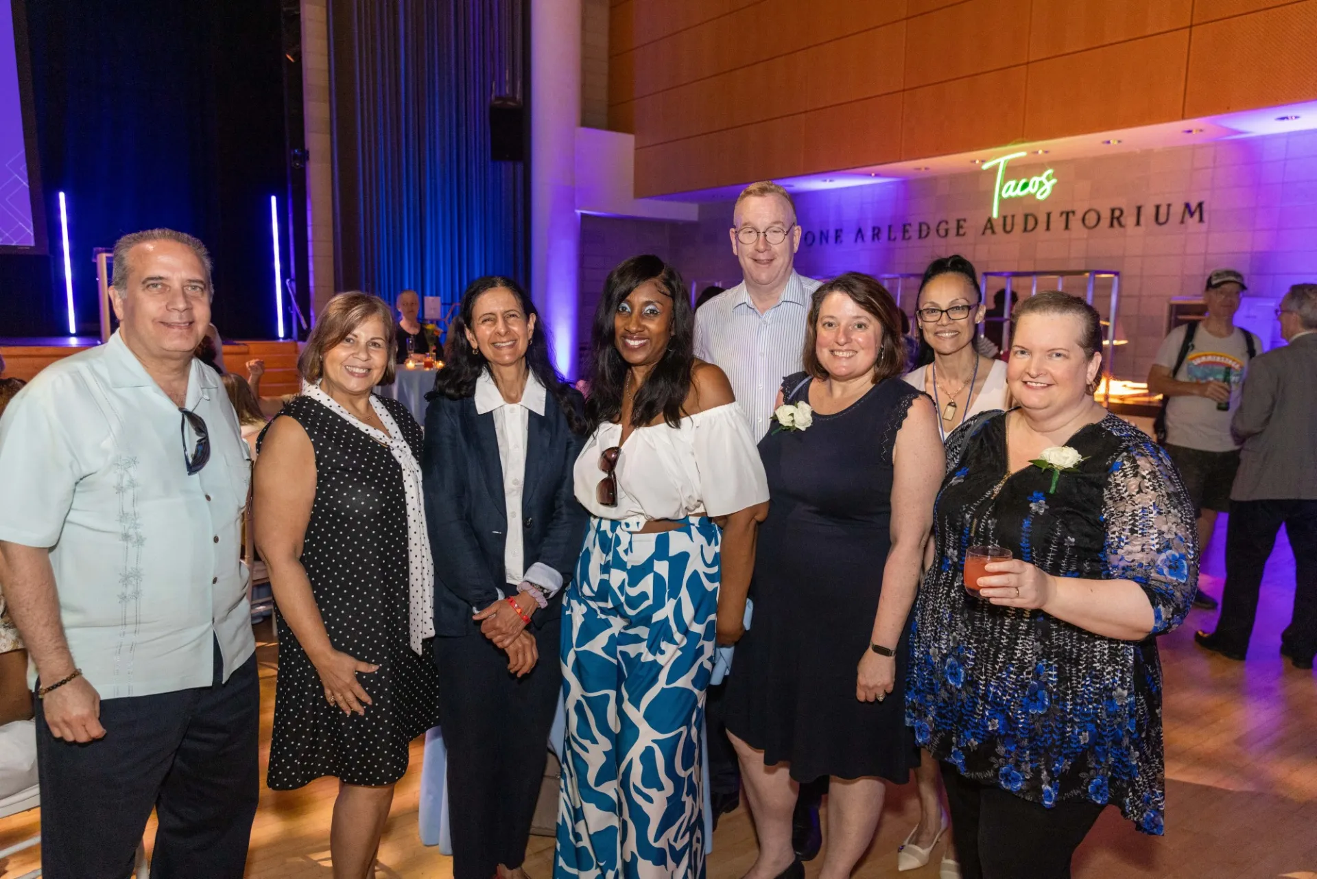 CUFO staff Nelson Falcon, Marah Arbaje, Monica Kuth, Theresa Todman, John Hogan, Terri Caldes, Annette Lopes, and JoEllen Bagayoko pose for a photo in Roone Arledge Auditorium.
