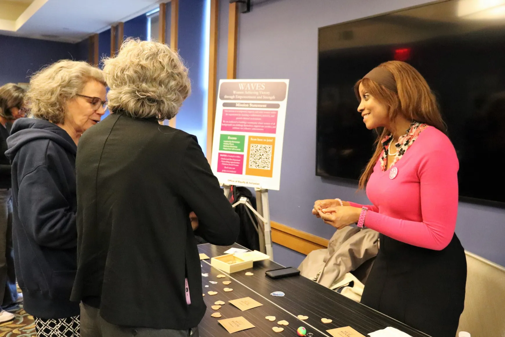 The chair of the Women Achieving Victory through Endurance and Strength group talking with employees