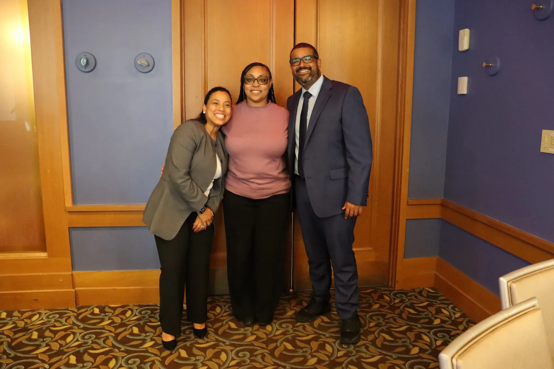 three people stand together smiling