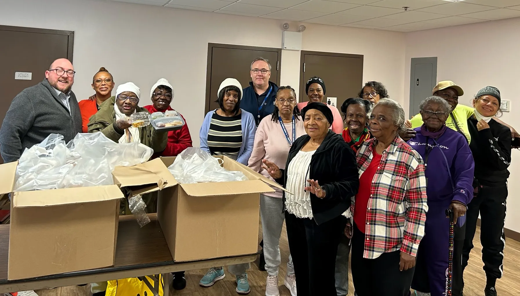 Facilities and Operations employees posing with local seniors and provided meals