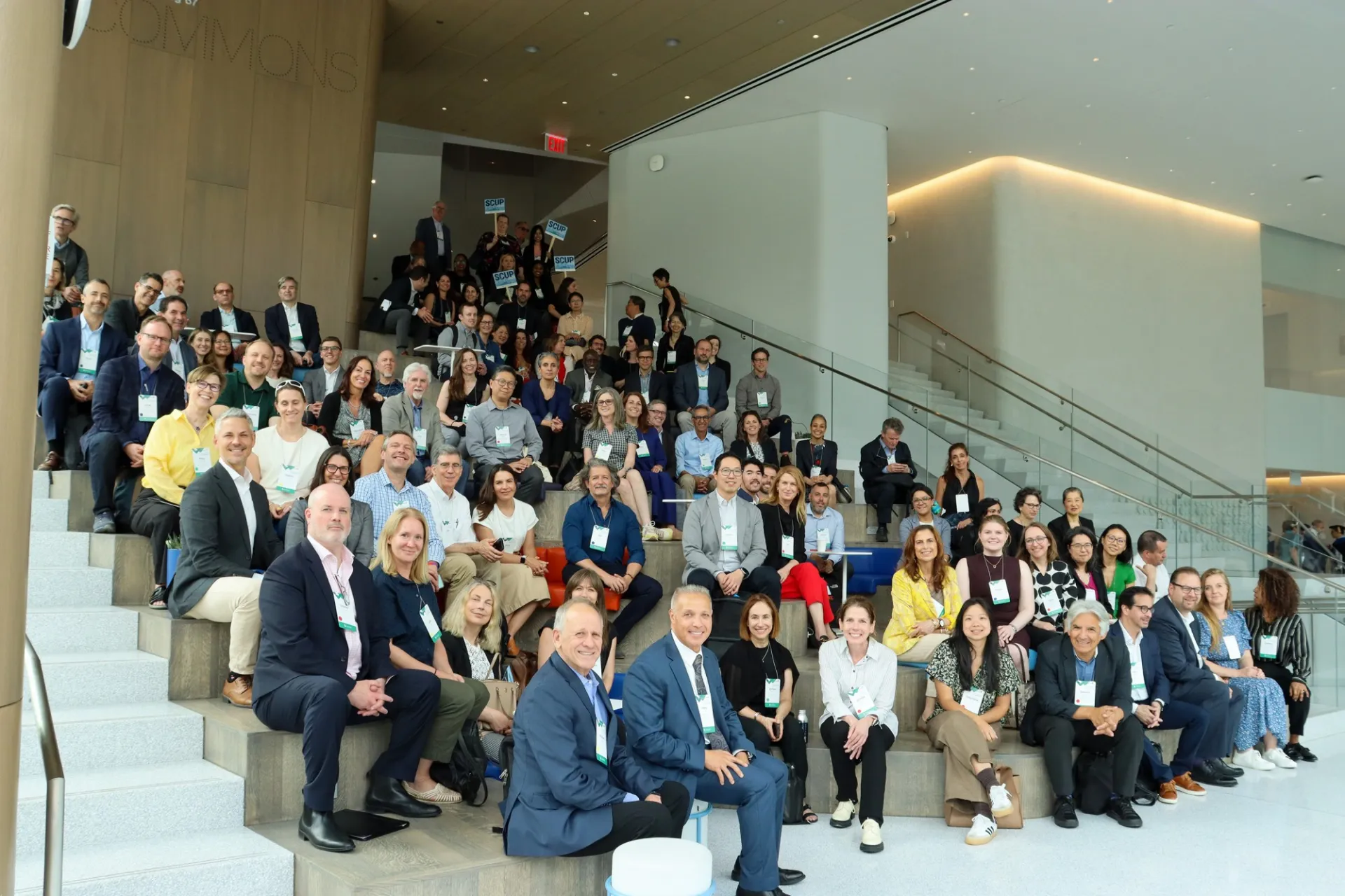 Attendees of the SCUP 2025 North Atlantic Symposium sit on the Commons in Columbia Business School and smile.