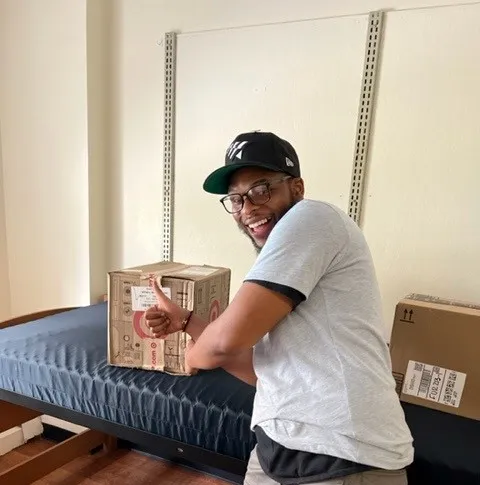 A member of the Student Mail team places a package in room.