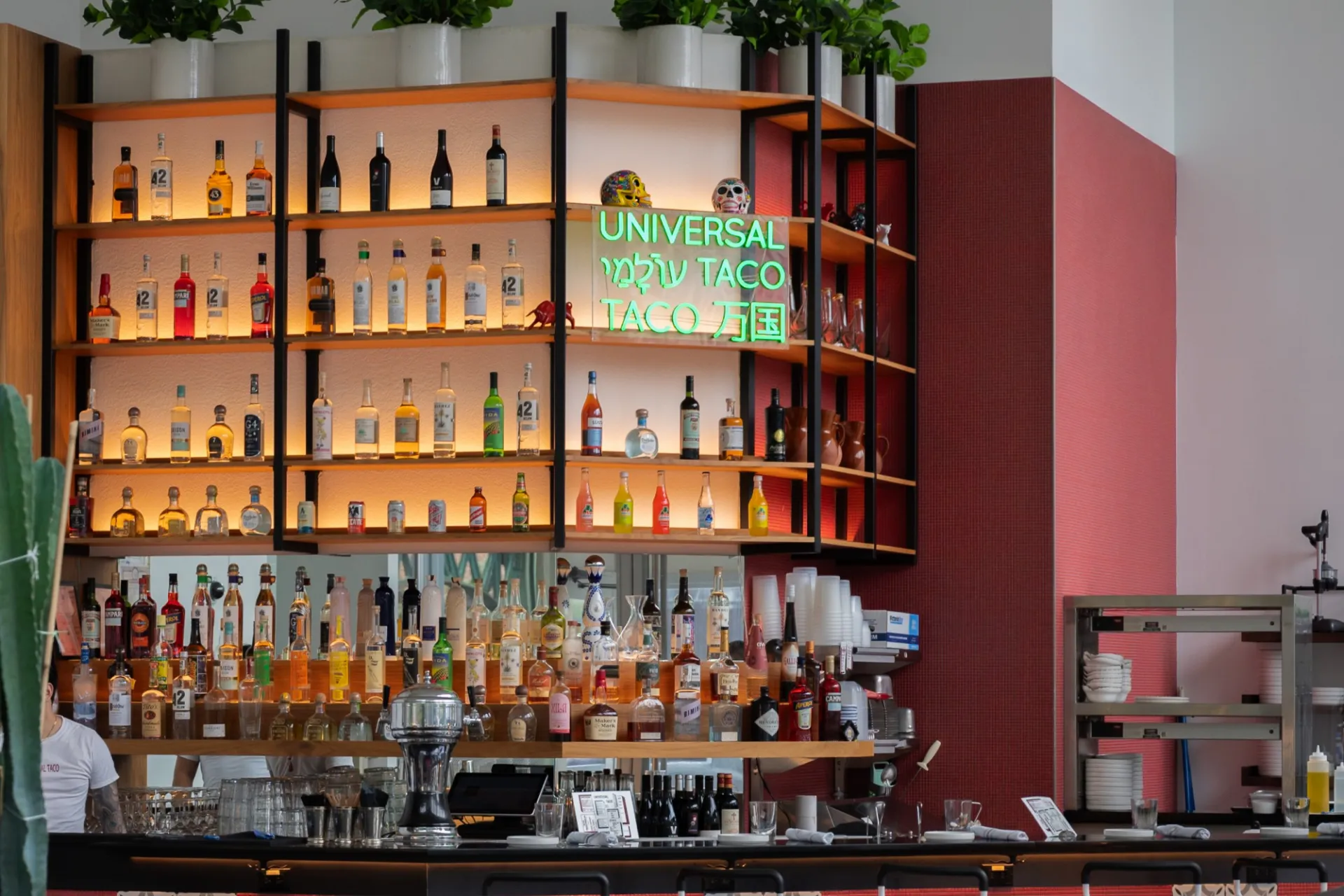 A full bar with several shelves on the wall that are full of liquor bottles.