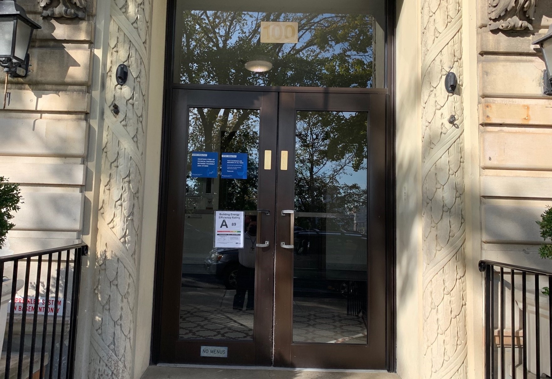 More than 80 percent of eligible Columbia buildings received A and B ratings. A residential building entrance that has an A energy efficency sign posted on the glass door.