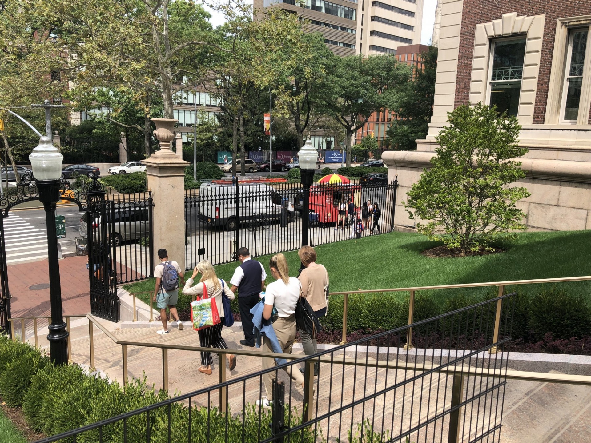 One of the many projects that occurred this summer was the renovation of the Earl Hall Gate stairs and surrounding walkways, flanked by two new lawn areas. People walking down Earl Hall Gate stairs, which was renovated with new open lawn areas.