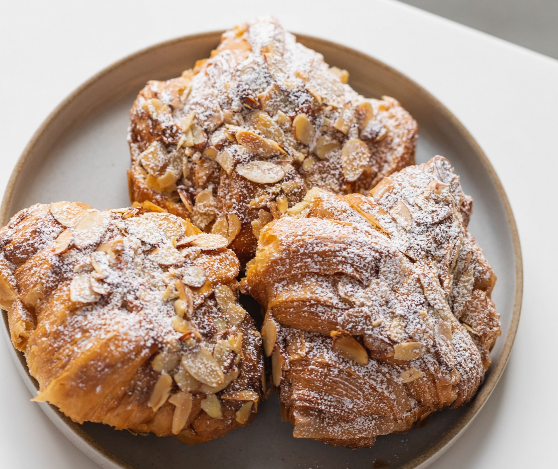 A plate full of almond croissants