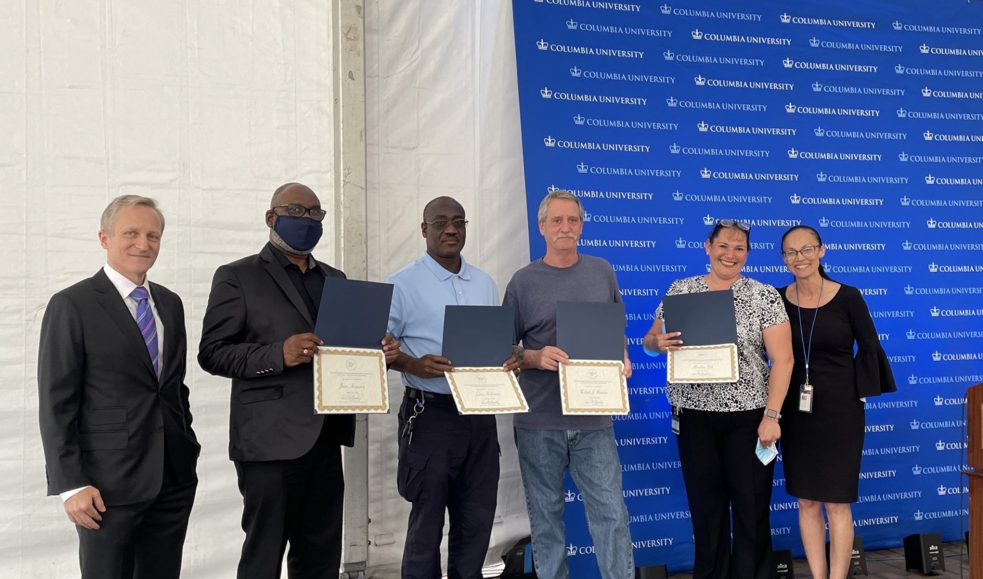 L-R: David Greenberg, Jean Augustine, Luno Ambroise, Robert Bavosa, Afrodita Sali, and Annette Lopes six people (four with certificates) posing in front a Columbia University step-and-repeat