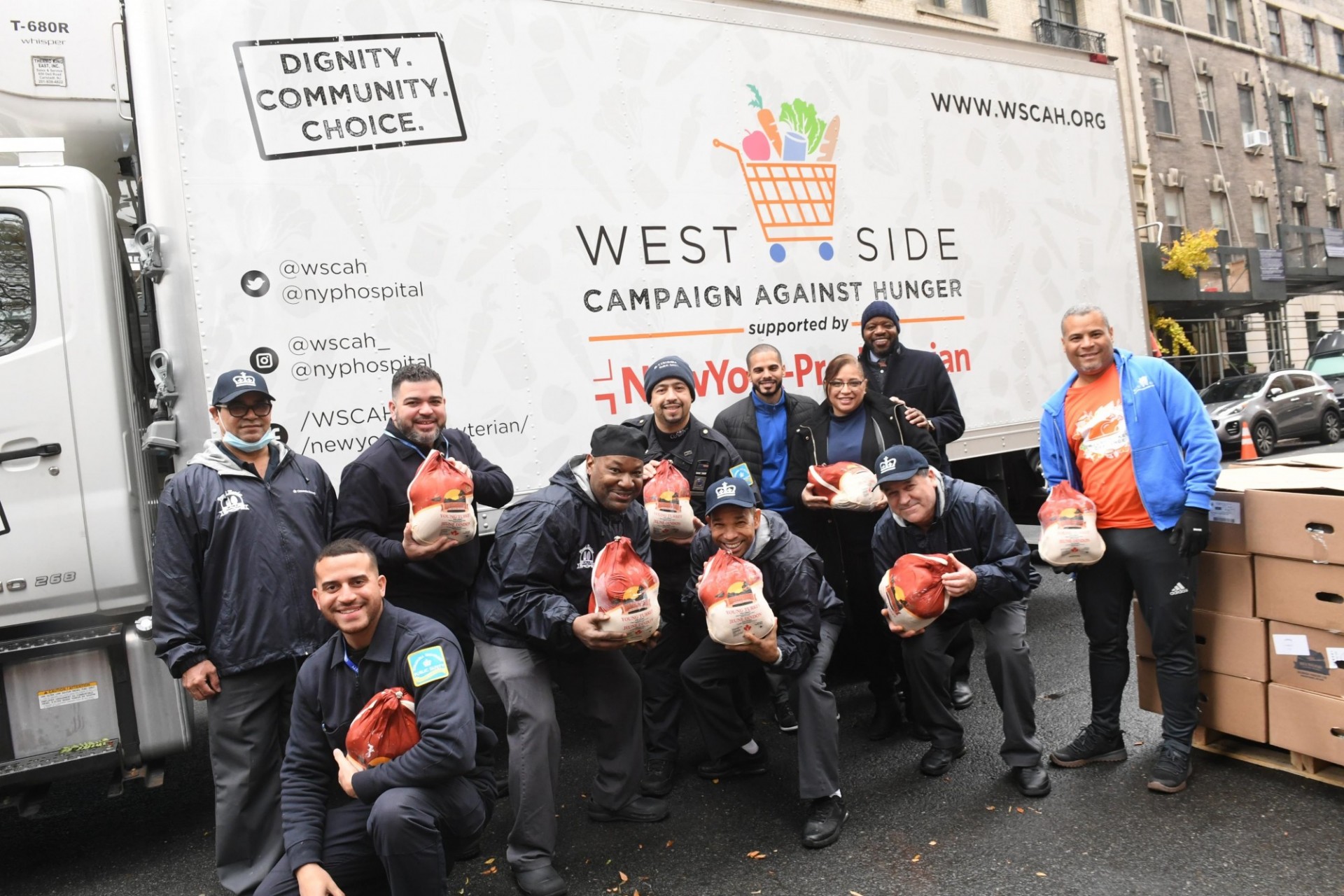 CUFO employees posing in front of truck that says: three people posing in front of truck that says: West Side Campaign Against Hunger