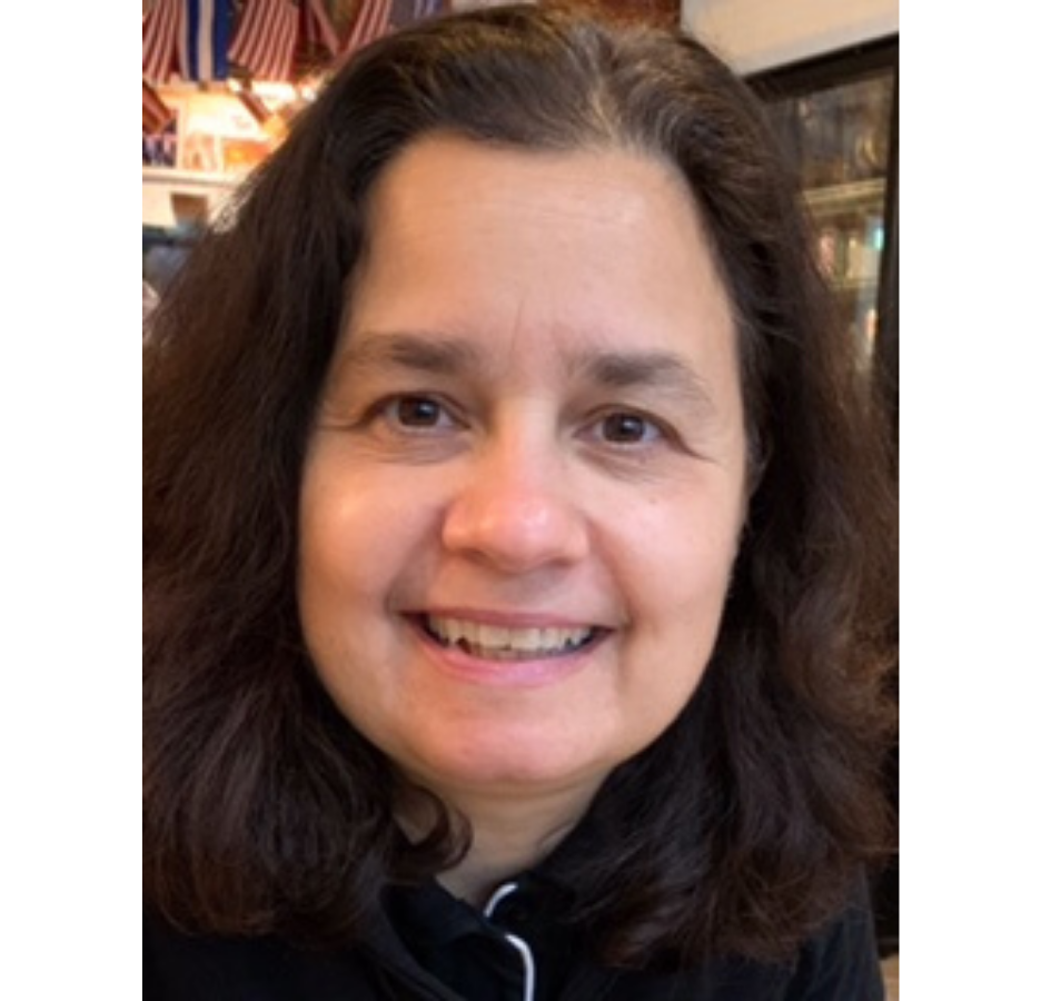 A woman with dark hair and brown eyes looks into the camera