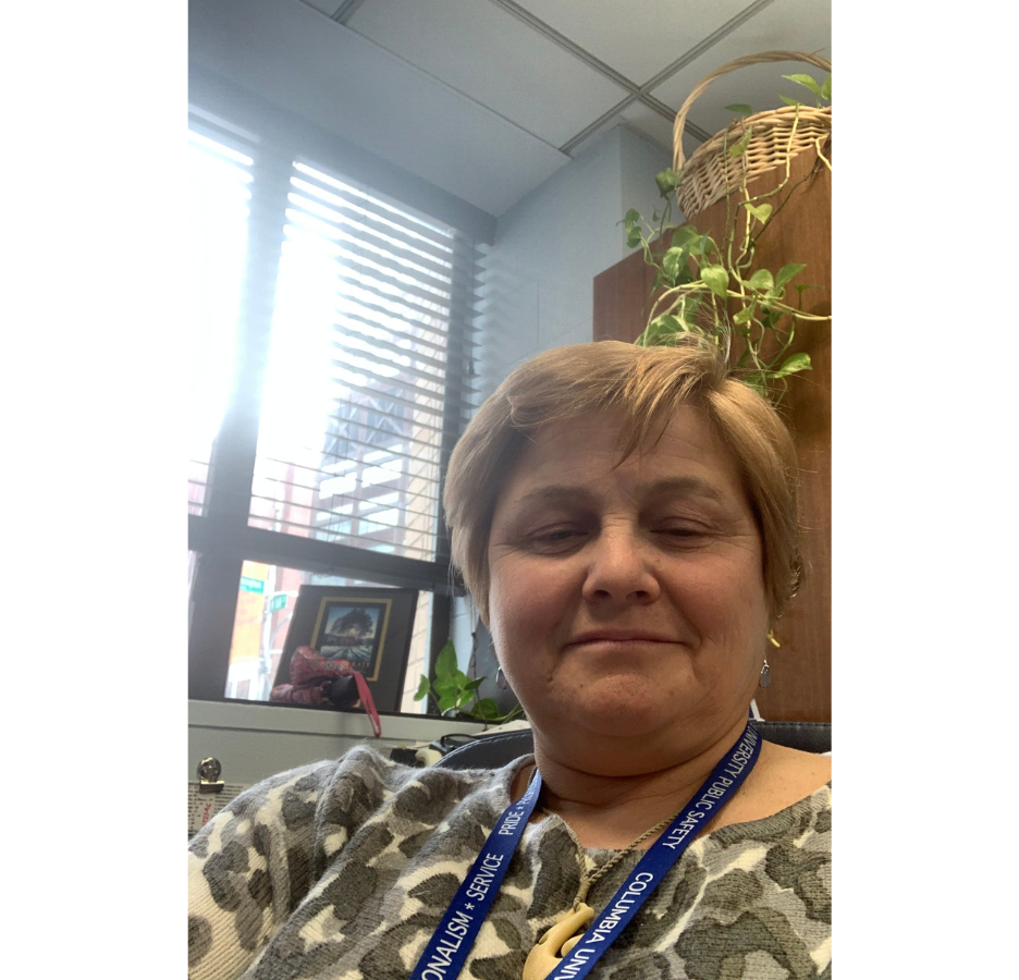 A woman sitting in an office smiles at the camera