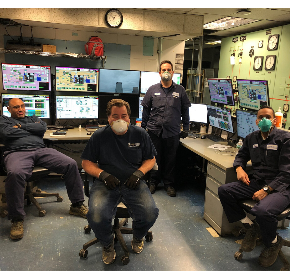 group of men in room with computers with masks on