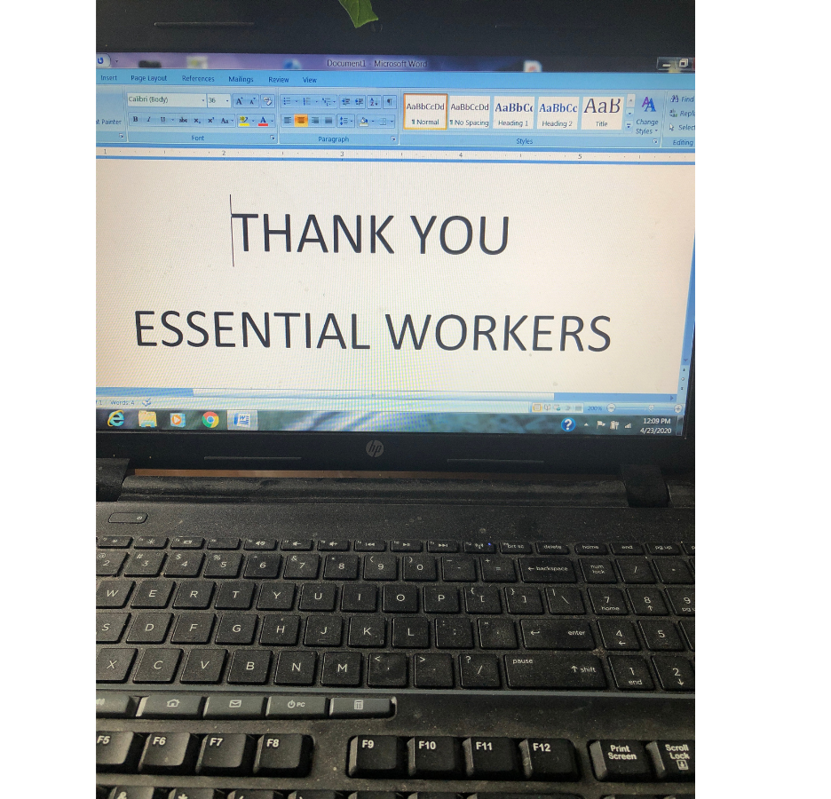 A note is typed on the screen of a laptop, "Thank you essential workers"