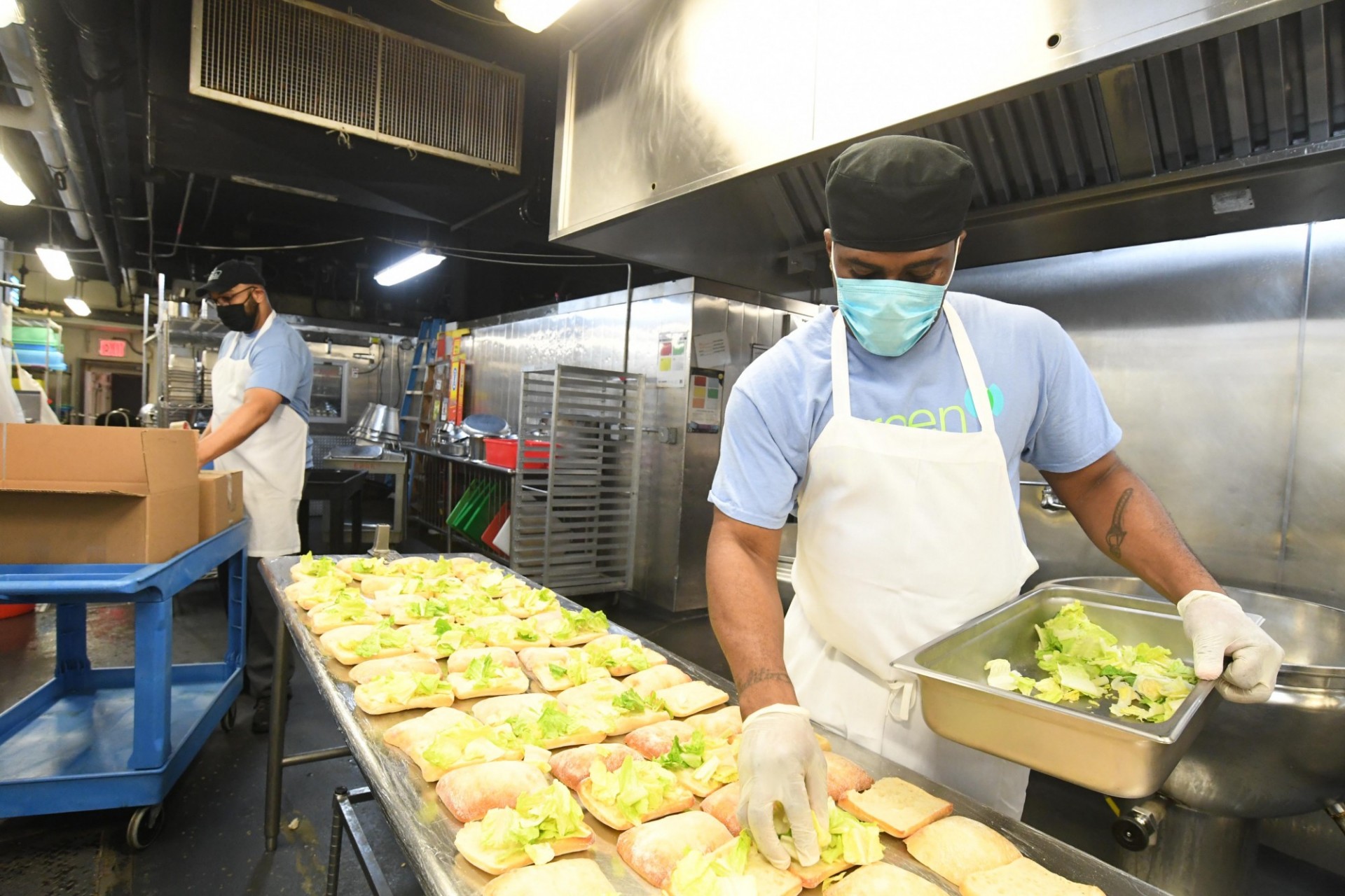 Dining staff member adds lettuce to sandwiches being prepared in John Jay Dining Hall
