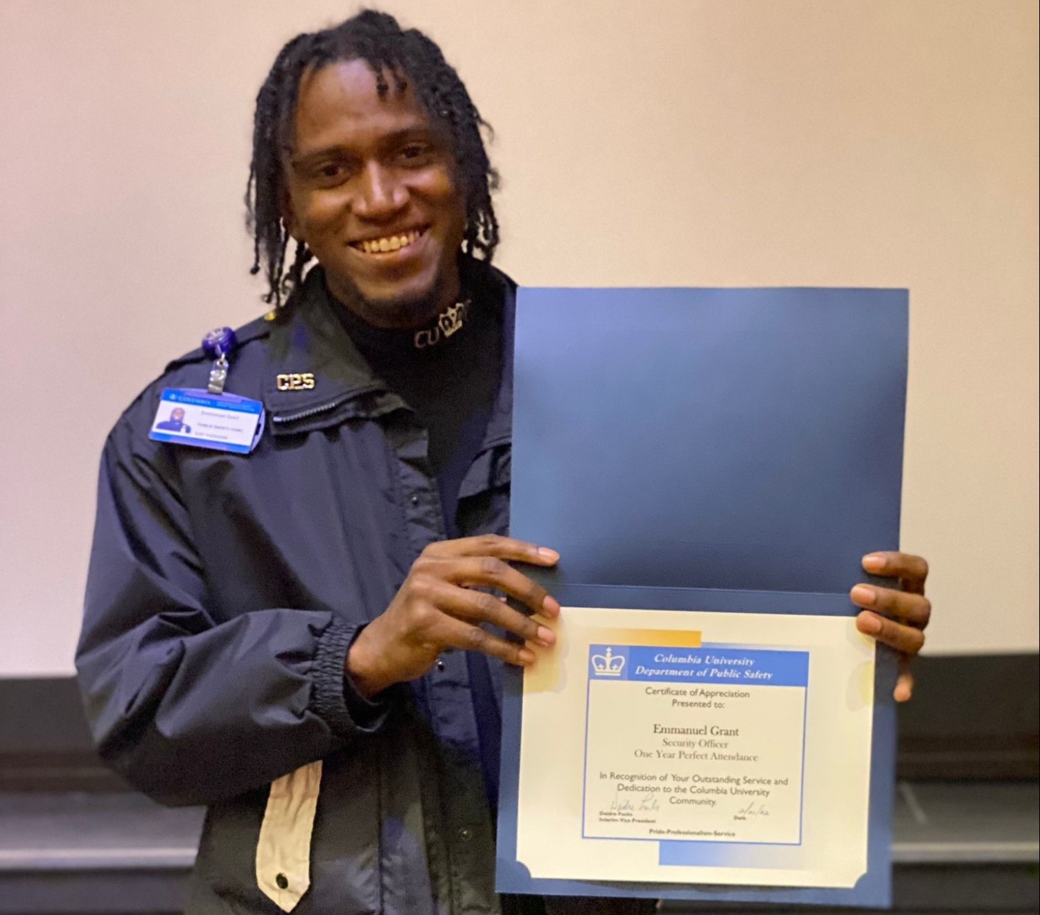 man in Public Safety uniform holding up a perfect attendance certificate