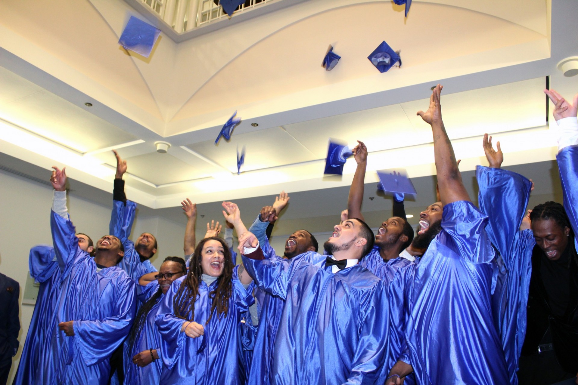 A graduation ceremony was held for students of the Upper Manhattan pre-apprenticeship program at Columbia University on December 4, 2019. Graduates throwing their hats up in the air after graduating.