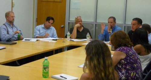 Approximately two dozen Facilities Operations team members and University department and school representatives discuss campus maintenance and renovation projects during a July 21st Production Meeting, led by Facilities Vice President of Operations Frank Martino (fourth from left).