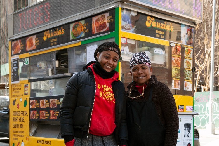 two women posing for photo in front of food truck