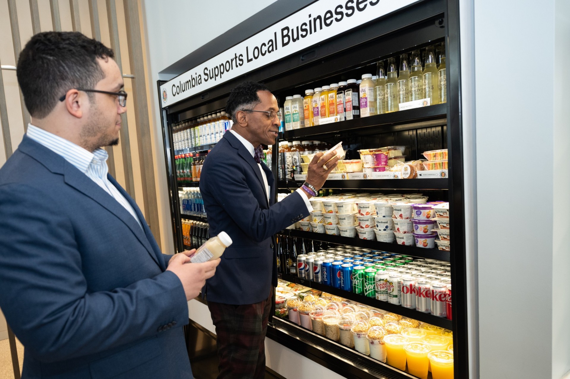 City Council Member Shaun Abreu and Assembly Member Al Taylor inspect the local vendors on display in the café on the ground floor of David Geffen Hall. Photo by Diane Bondareff.