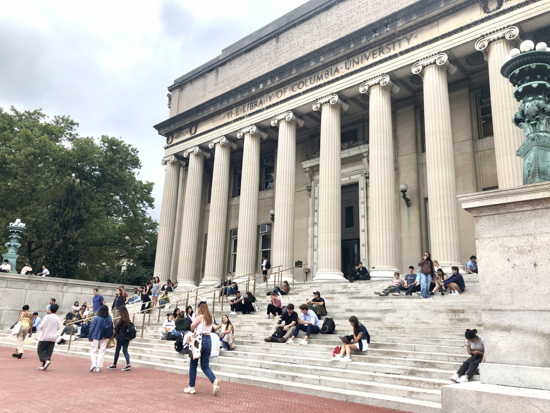 Students sit on the newly rehabilitated granite steps leading to the entrance of Low Library.