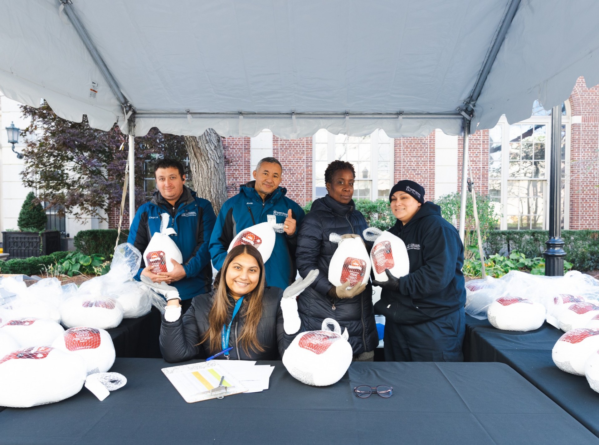 Columbia Residential distributes Thanksgiving turkeys to CUFO employees. Photo by Kevin Dale. Columbia Residential employees posing with turkeys.