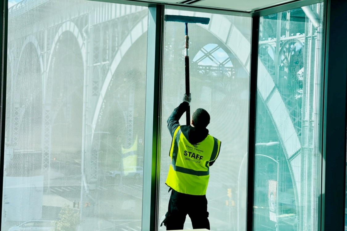 A window cleaner is washing a large building window.