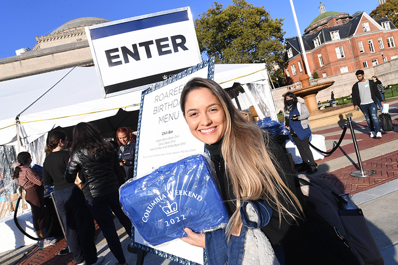 Student holding event blanket outside of event tent