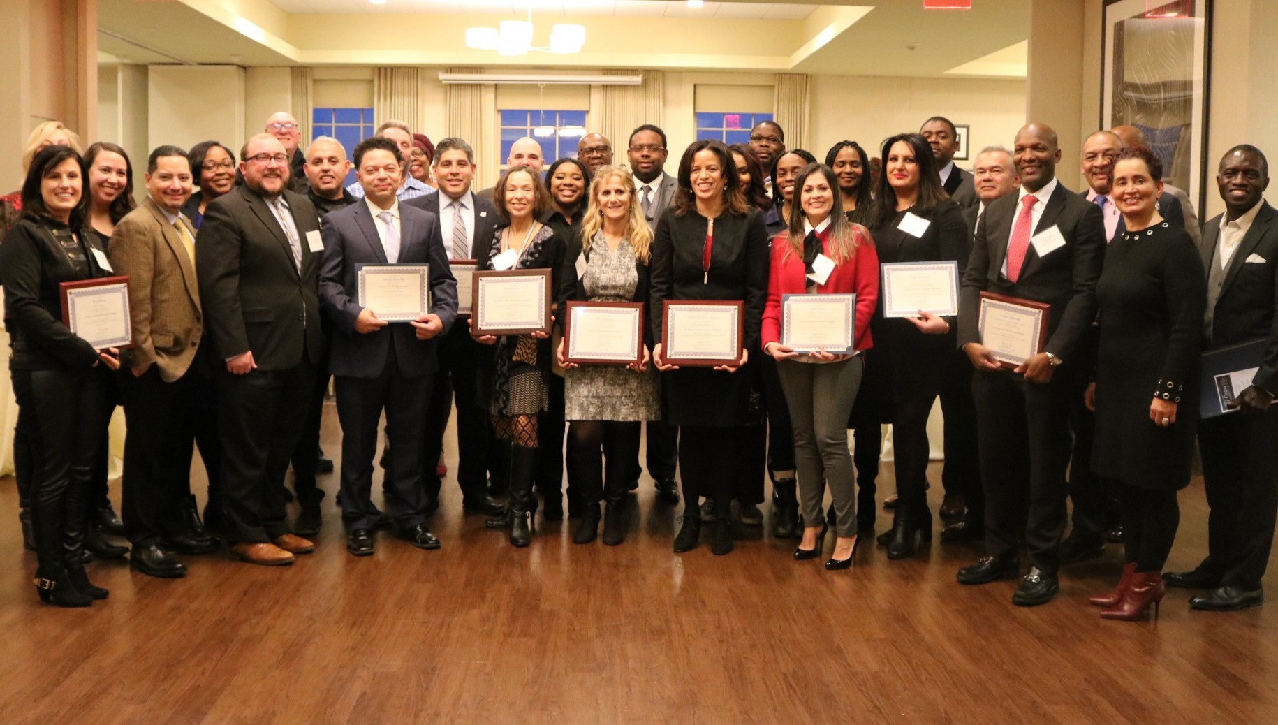 The CU Grow 2018 cohort stand with their coaches while displaying their certificates at the graduation ceremony